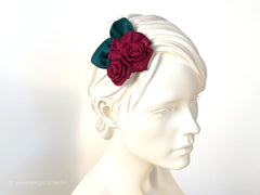 Fascinator Hair flowers with deep red Roses with dark green leaves.