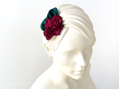 Fascinator Hair flowers with deep red Roses with dark green leaves.