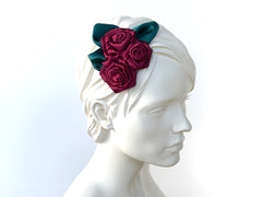 Fascinator Hair flowers with deep red Roses with dark green leaves.