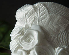 FASCINATOR - BRIDAL HEADPIECE WITH ROSES ON A BRAIDED BASE IN PURE WHITE AND OTHER SHADES © Seegang Berlin